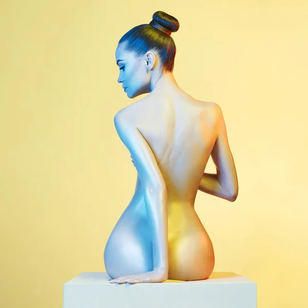 Elegante naakt model in de licht gekleurde spotlights — Stockfoto