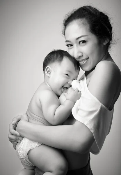 Mladá Asijská matka drží její miminko a prsní krmení dítěte v b — Stock fotografie