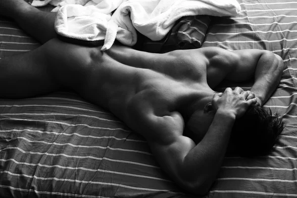 Kaslı adam yatakta — Stok fotoğraf